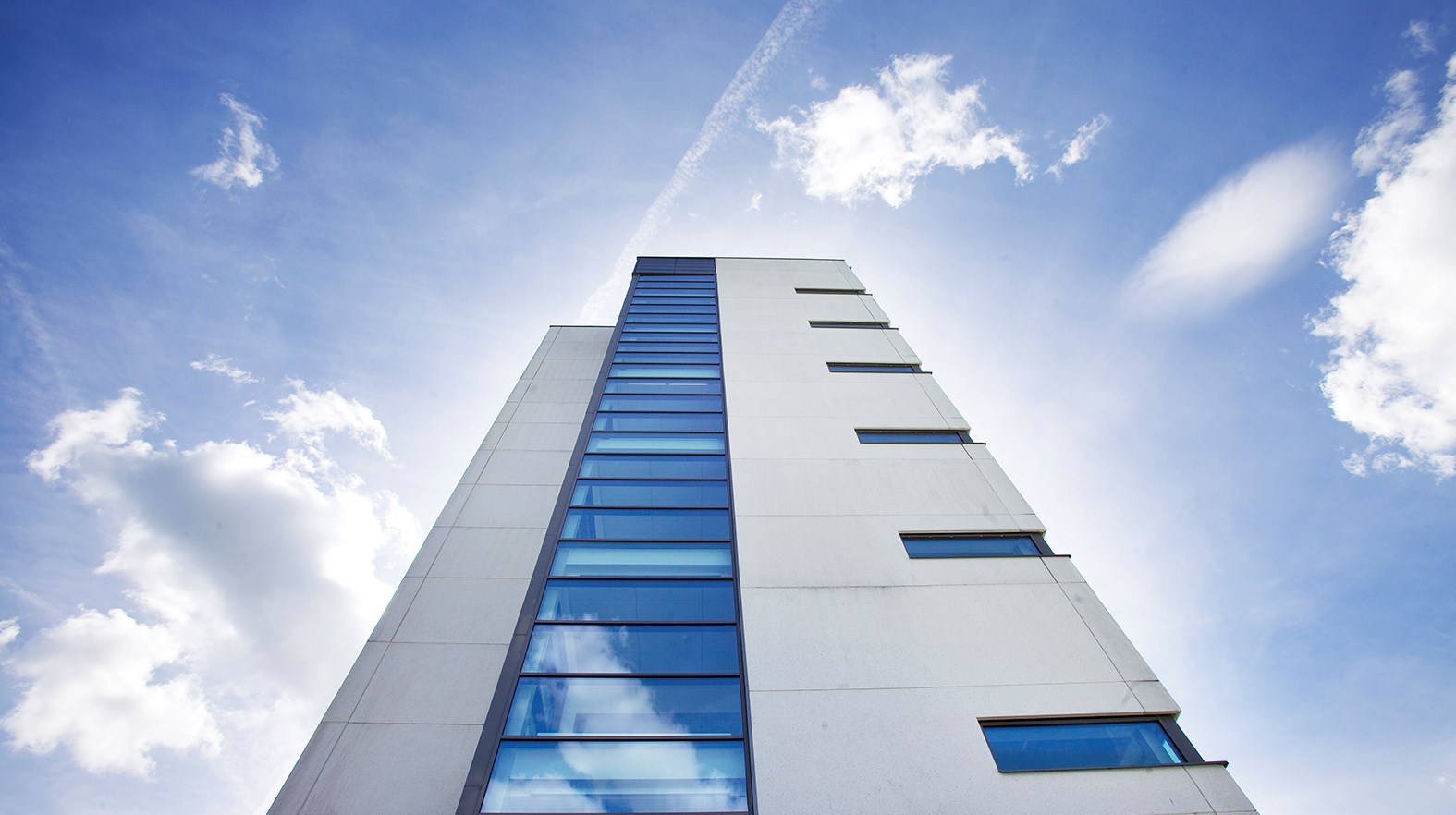 Ett vitt höghus mot en blå himmel